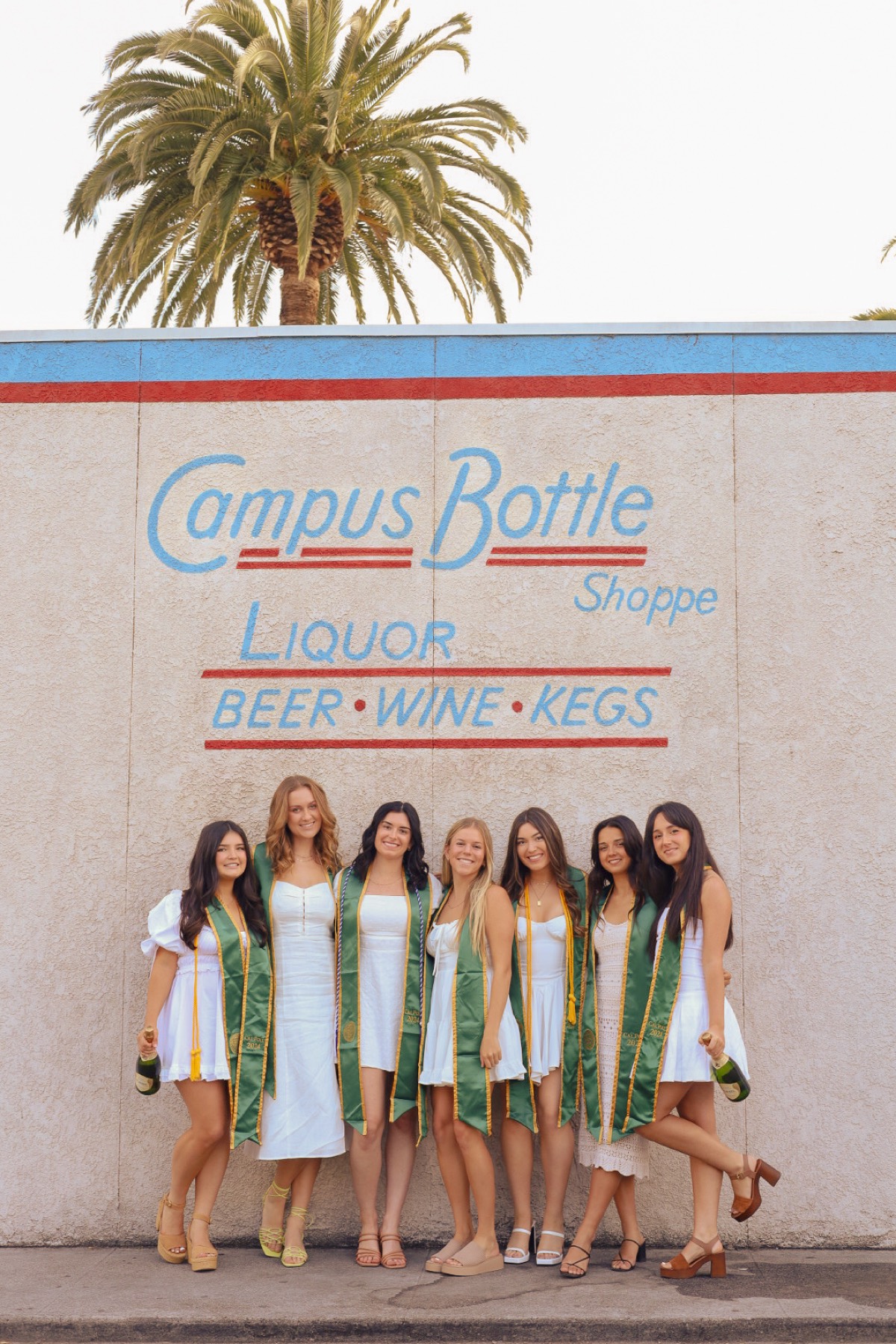 Group of graduates in front of the Campus Bottle mural