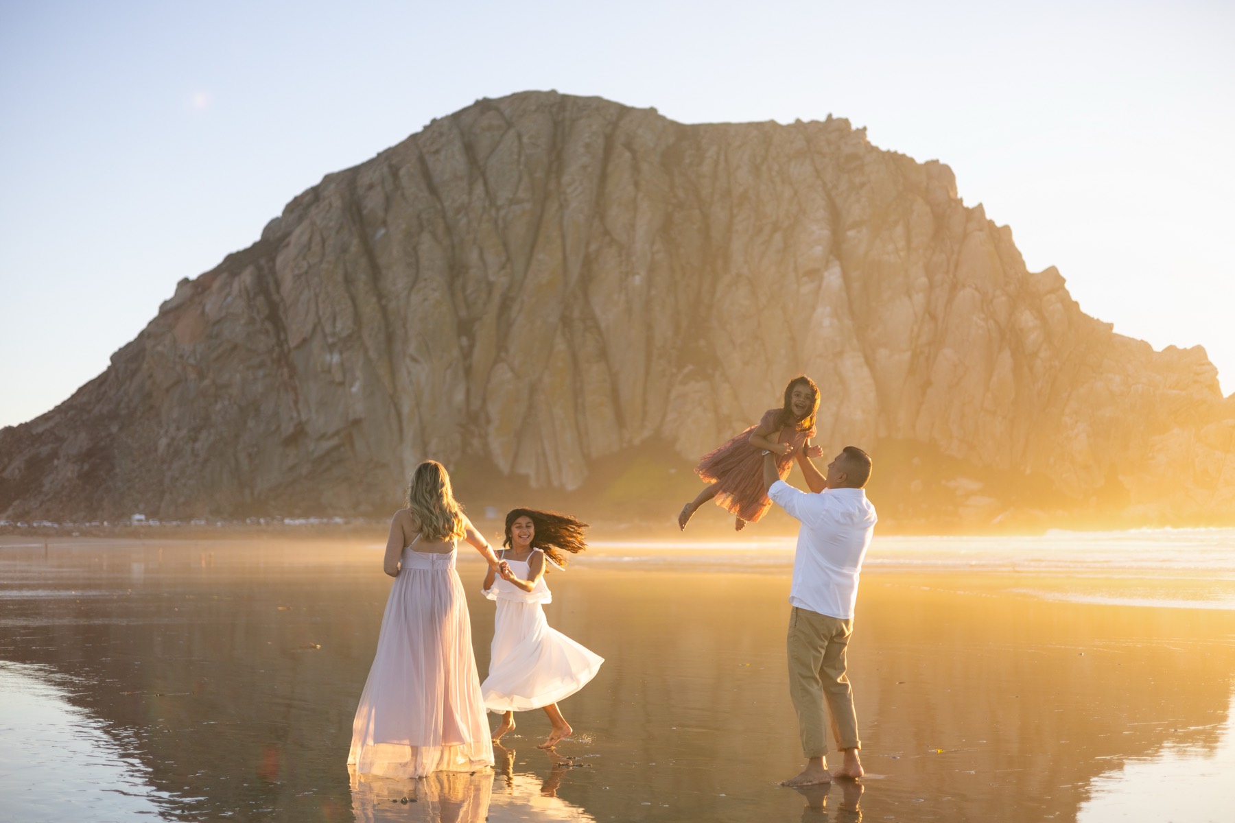 Dad lifting his daughter into the air at Morro Rock