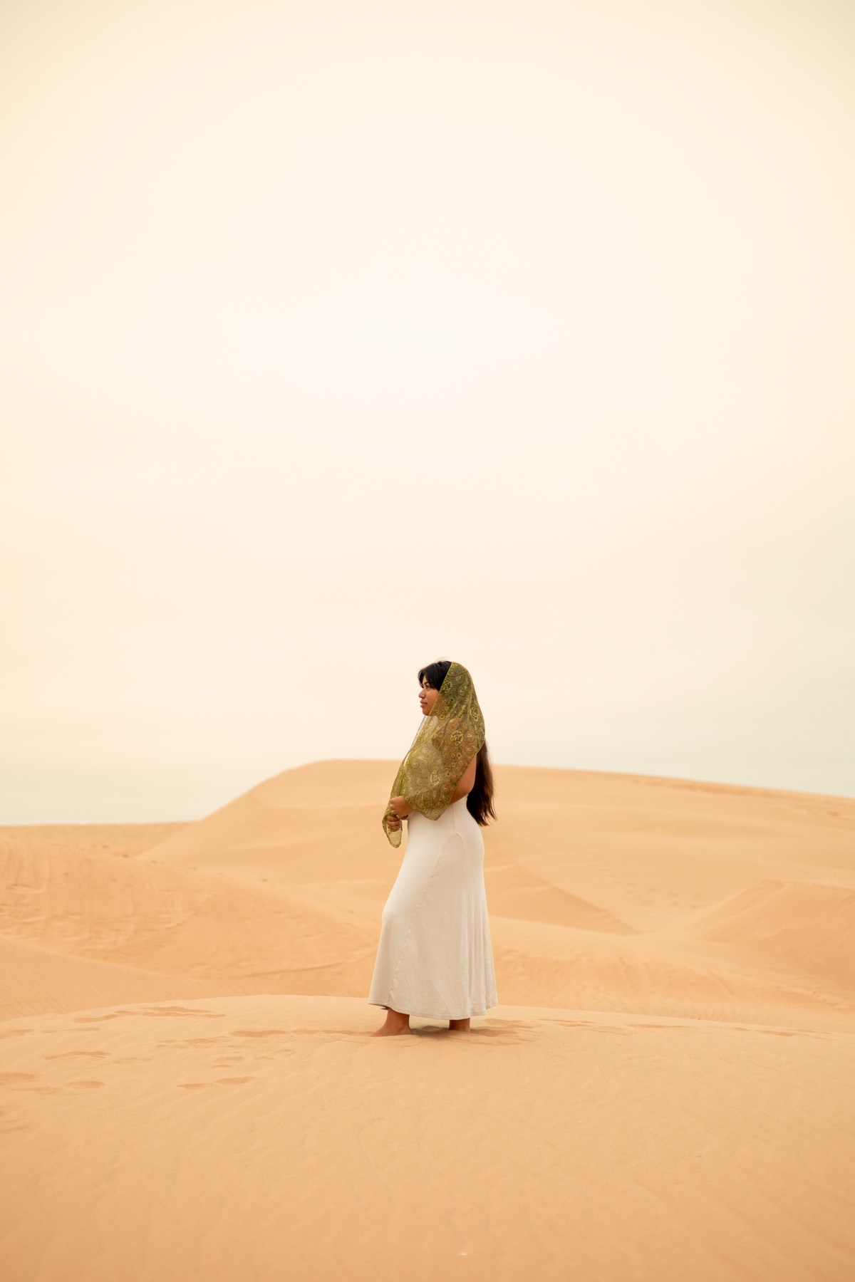 Portrait in a white dress and scarf on the dunes