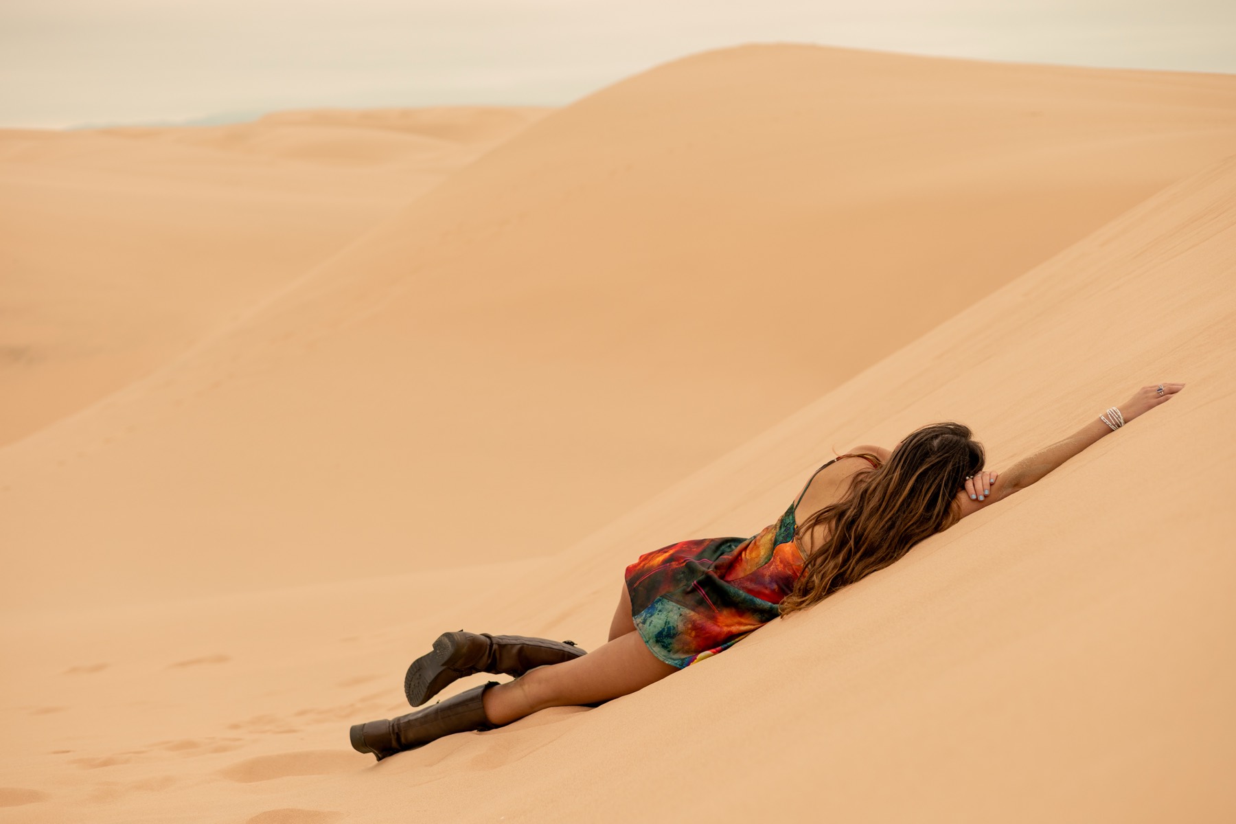 Portrait lying across a sand dune